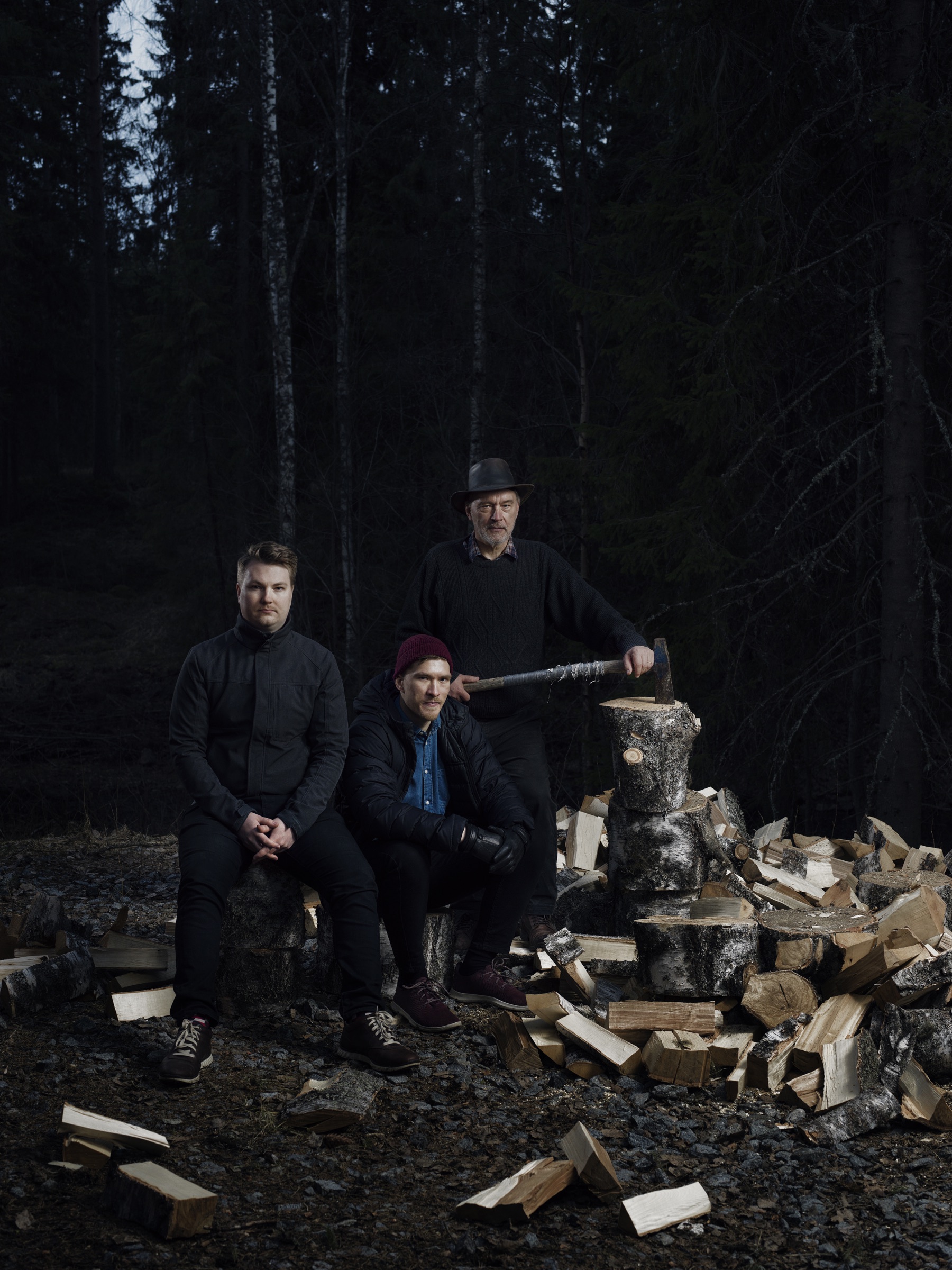Logmore founders in a Finnish forest beside chopped firewood